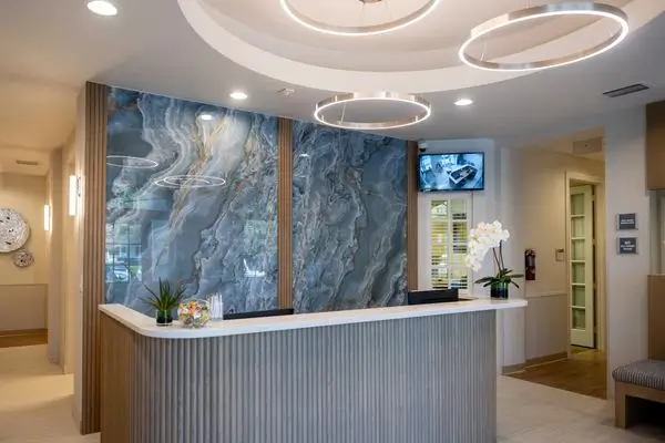 A reception desk with a large stone wall behind it.